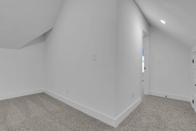 additional living space with vaulted ceiling, carpet flooring, and baseboards