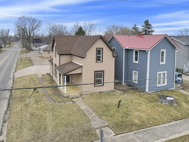 traditional-style home with metal roof and a front yard