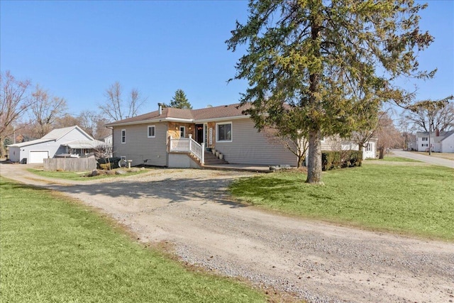 ranch-style house with a front yard and dirt driveway