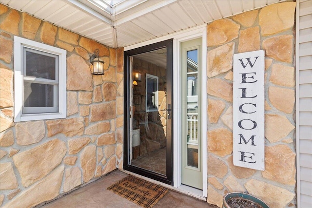 doorway to property featuring stone siding