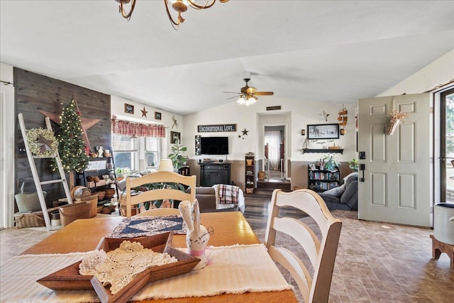 dining area featuring vaulted ceiling, stone finish floor, and ceiling fan