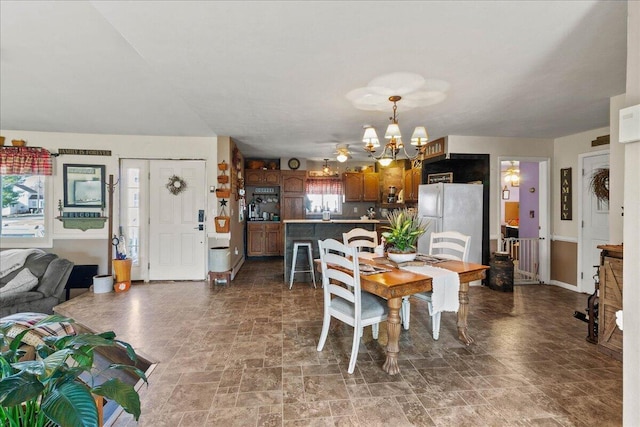 dining room featuring stone finish flooring and an inviting chandelier