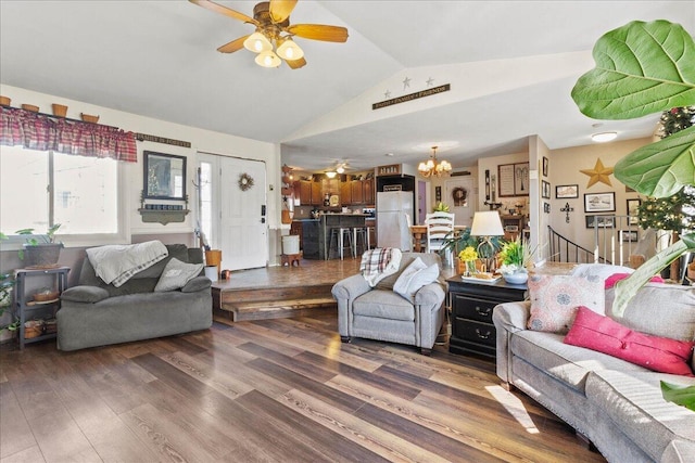 living room featuring ceiling fan with notable chandelier, lofted ceiling, stairs, and wood finished floors