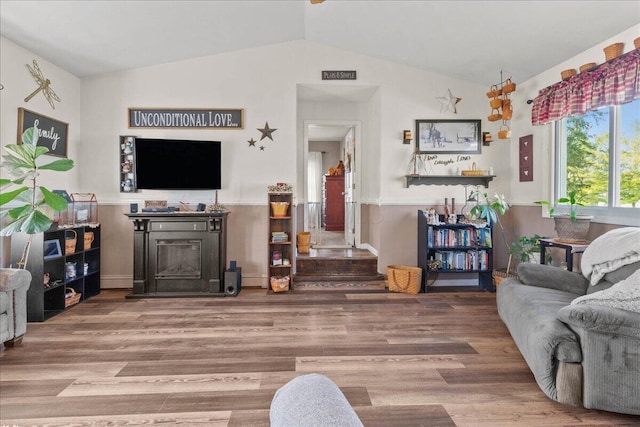 living room with lofted ceiling and wood finished floors