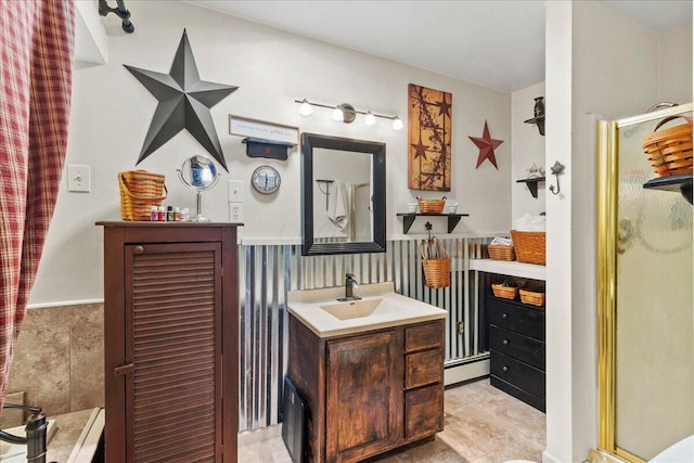 bathroom with an enclosed shower, a wainscoted wall, vanity, and a baseboard heating unit