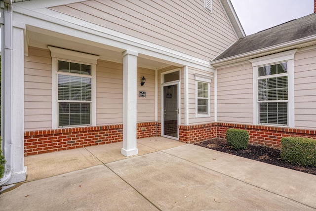 property entrance with brick siding and roof with shingles