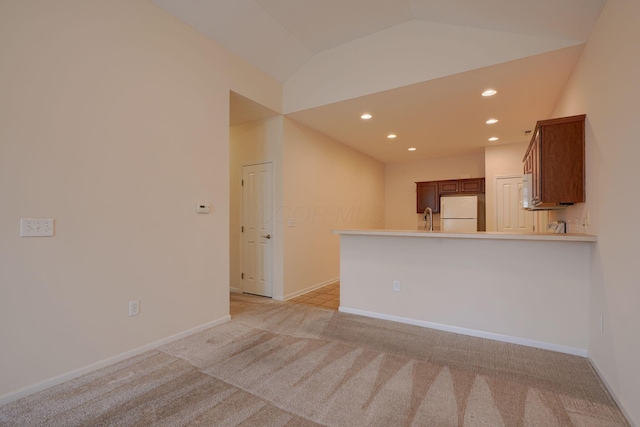 unfurnished room featuring baseboards, recessed lighting, a sink, vaulted ceiling, and light colored carpet