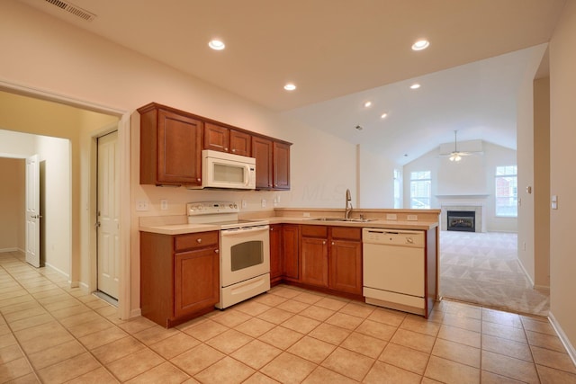 kitchen with visible vents, light countertops, a peninsula, white appliances, and a sink