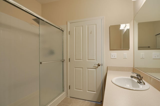 bathroom with tile patterned floors, a stall shower, and vanity