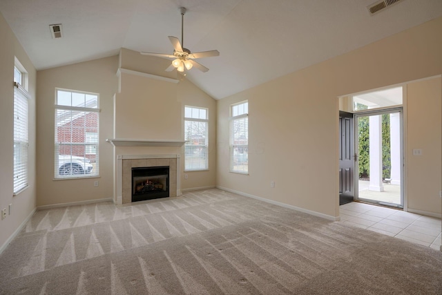 unfurnished living room featuring light tile patterned floors, visible vents, baseboards, a fireplace, and light colored carpet