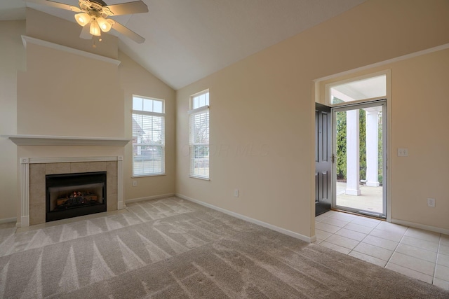 unfurnished living room with baseboards, carpet floors, high vaulted ceiling, tile patterned flooring, and a tiled fireplace