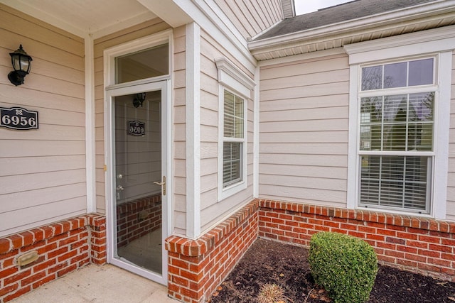 entrance to property featuring brick siding