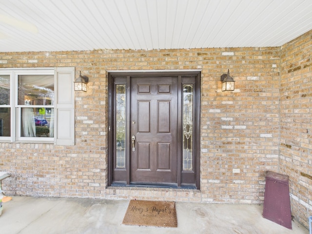 doorway to property featuring brick siding