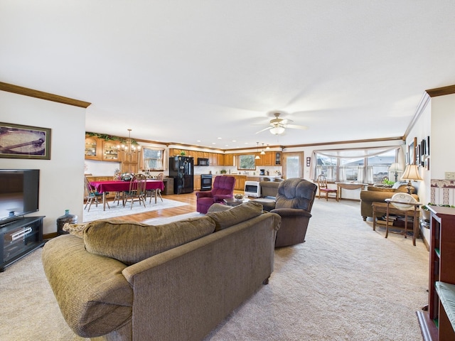 living area featuring light carpet, crown molding, and ceiling fan with notable chandelier