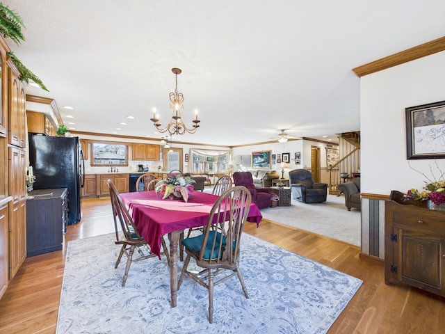 dining room with recessed lighting, ornamental molding, stairs, ceiling fan with notable chandelier, and light wood-type flooring