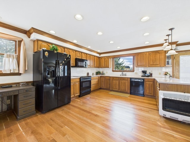 kitchen featuring heating unit, black appliances, brown cabinetry, and crown molding