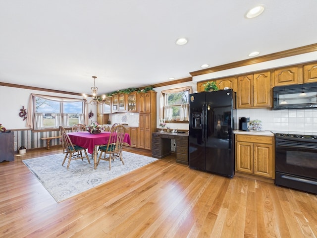 kitchen with light wood-type flooring, black appliances, and brown cabinetry