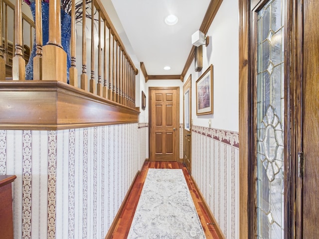 hallway with a wainscoted wall, recessed lighting, wood finished floors, and ornamental molding