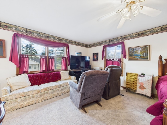 living area with a ceiling fan, a healthy amount of sunlight, and light carpet