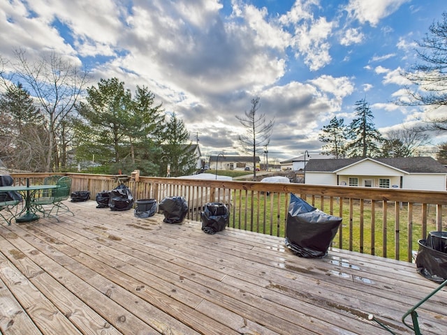 wooden terrace featuring a lawn