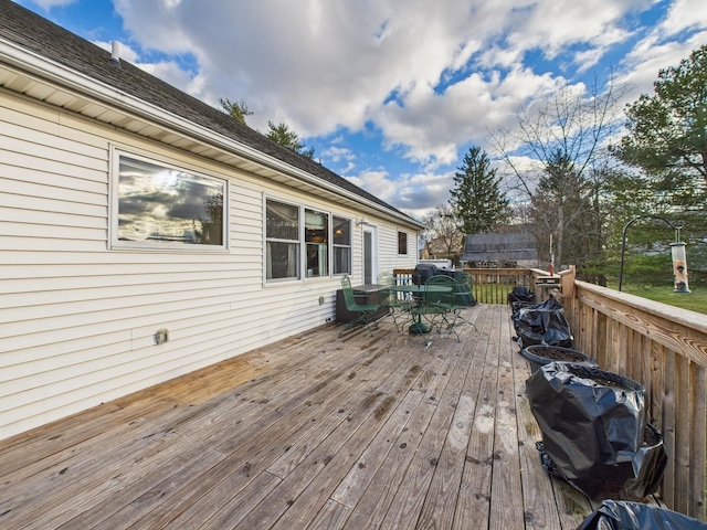 deck with outdoor dining space and grilling area