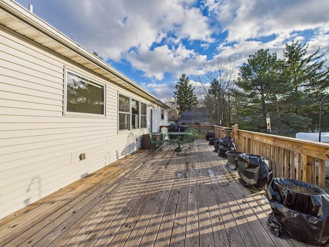 wooden deck featuring area for grilling and outdoor dining area