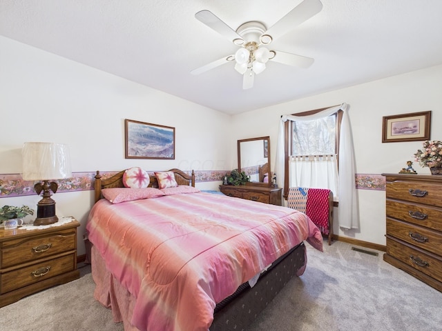 bedroom with light carpet, visible vents, baseboards, and ceiling fan