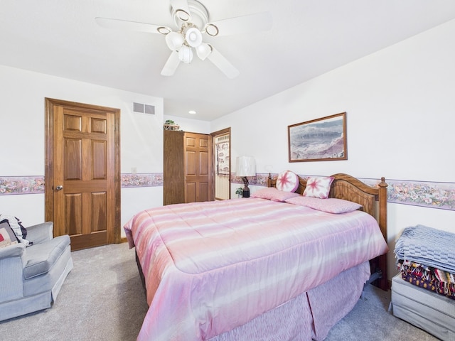 bedroom with light carpet, visible vents, and ceiling fan