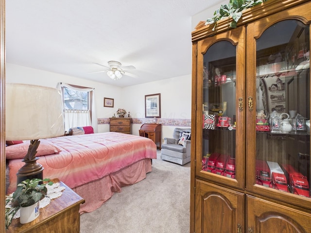 bedroom with light colored carpet and a ceiling fan