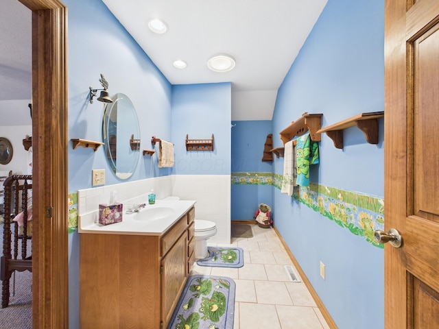 bathroom with vanity, baseboards, visible vents, tile patterned floors, and toilet