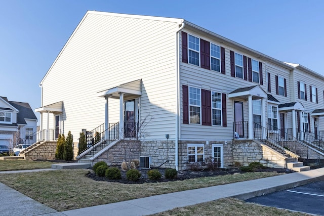 multi unit property featuring stone siding and central AC unit