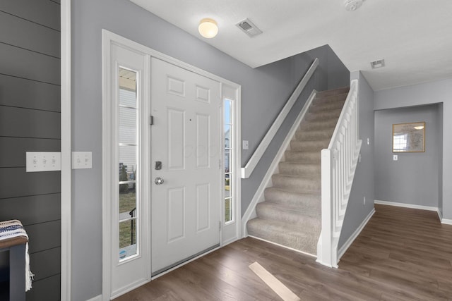 foyer entrance featuring stairs, wood finished floors, visible vents, and baseboards