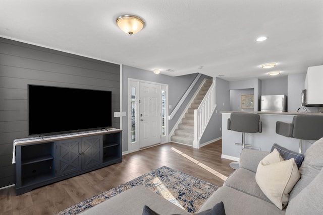 living room with stairway, recessed lighting, wood finished floors, and baseboards