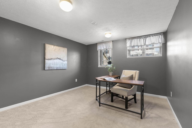 carpeted home office featuring baseboards and a textured ceiling