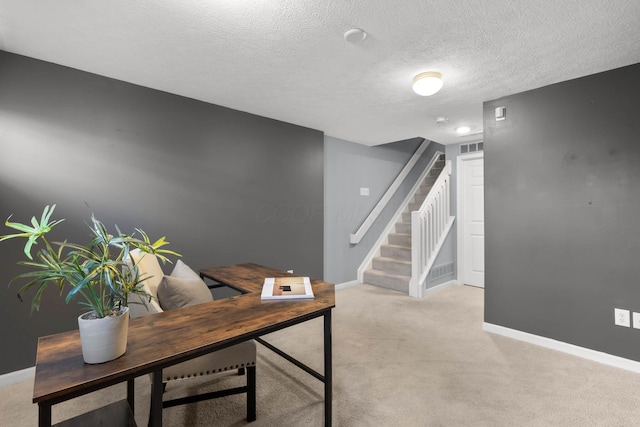 home office with a textured ceiling, baseboards, and light carpet