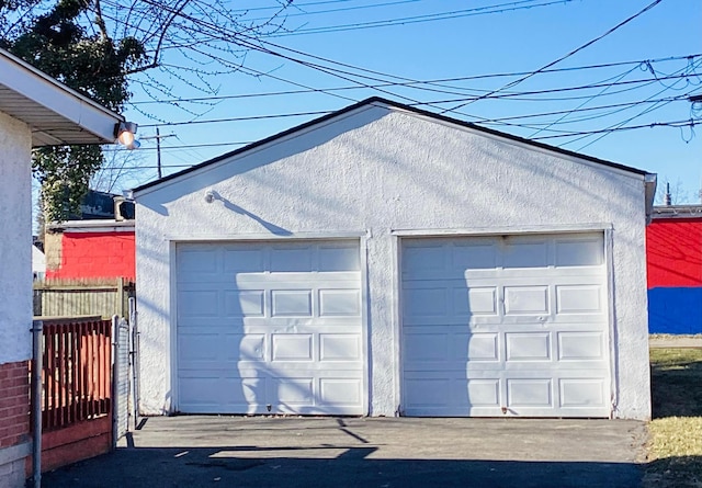 detached garage featuring fence