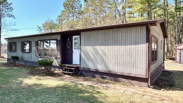 view of front of home with entry steps and a front lawn