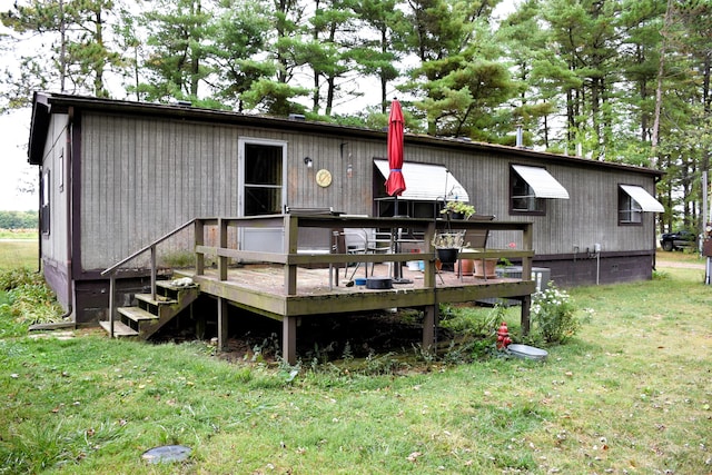 back of house with a wooden deck and a yard