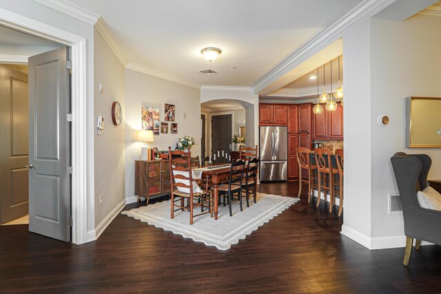 dining space with visible vents, dark wood-style floors, arched walkways, and ornamental molding