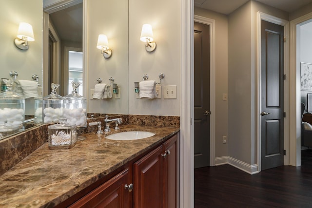 bathroom with baseboards, wood finished floors, and vanity