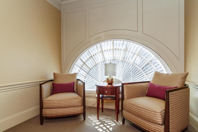 sitting room with a decorative wall and carpet