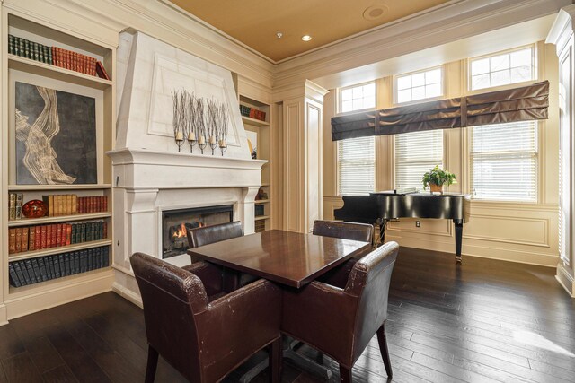 dining room featuring dark wood-style floors, a lit fireplace, and ornamental molding