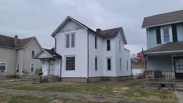 view of front facade featuring a front yard and a chimney