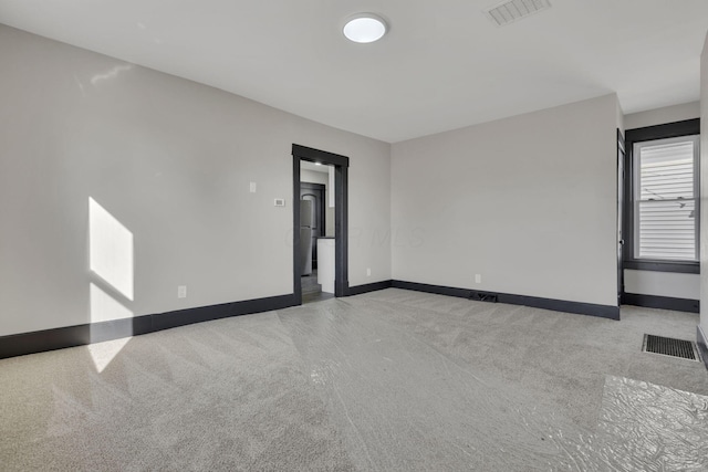 carpeted spare room with baseboards and visible vents