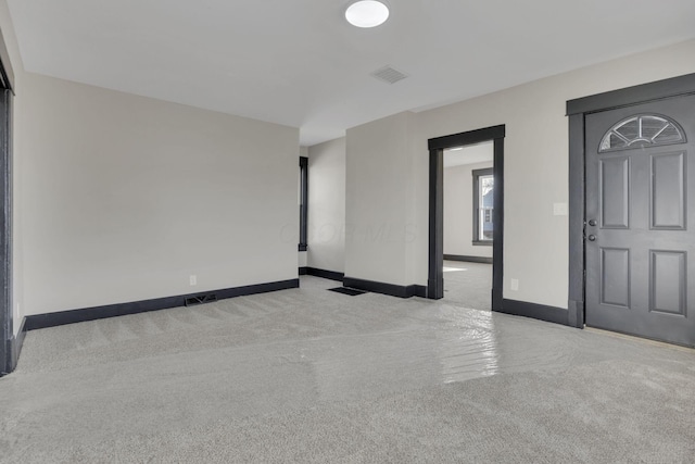 empty room with visible vents, carpet, and baseboards