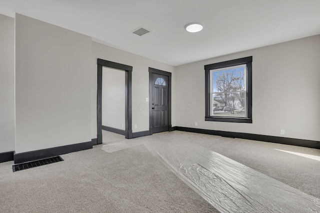 entryway with light carpet, visible vents, and baseboards