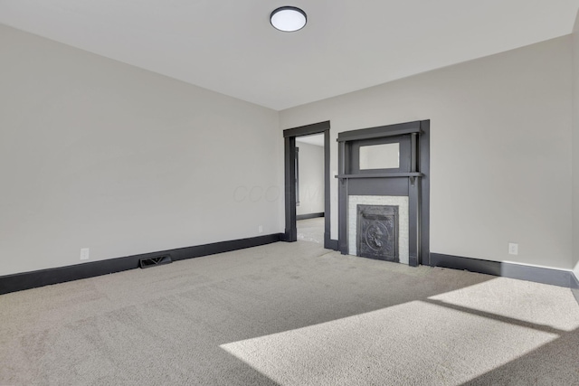 unfurnished living room with visible vents, baseboards, carpet, and a fireplace