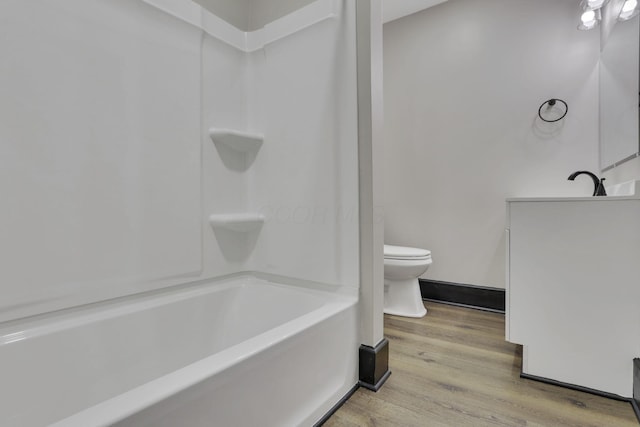 full bathroom with toilet, vanity, baseboards, and wood finished floors