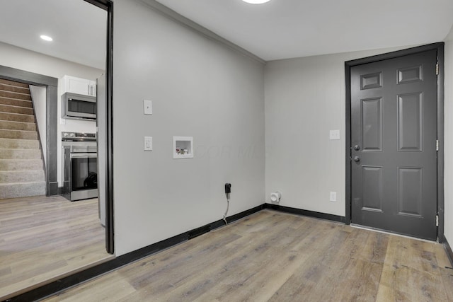 washroom featuring light wood finished floors, laundry area, baseboards, and washer hookup