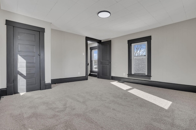 carpeted spare room featuring baseboards